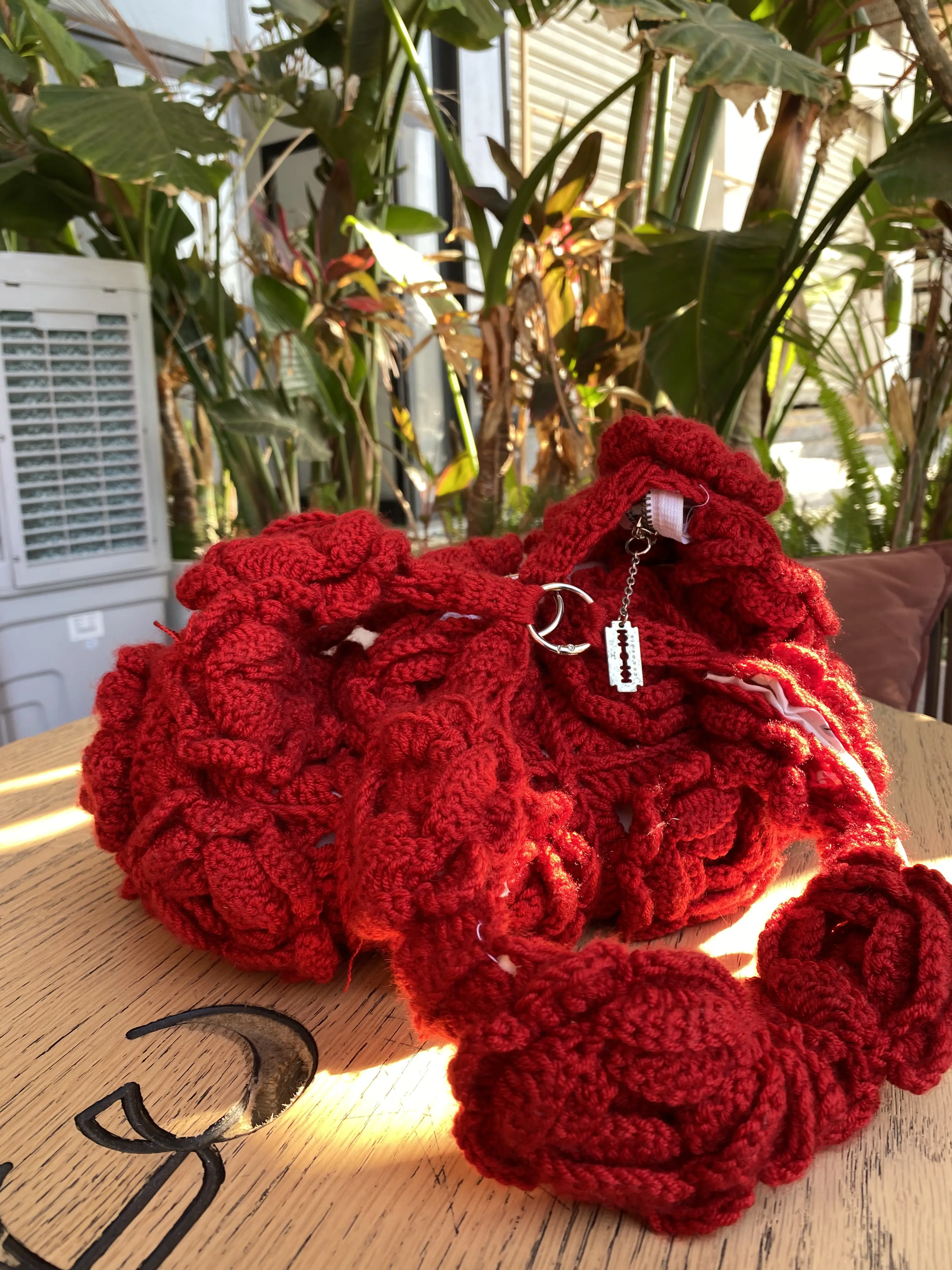 Red handmade crochet rose bags displayed outdoors